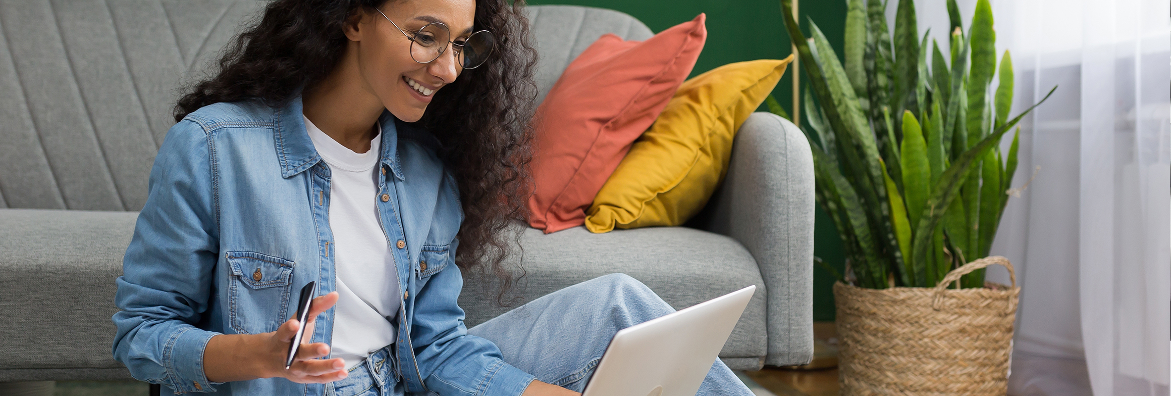 Woman sitting on floor with laptop reviewing investments