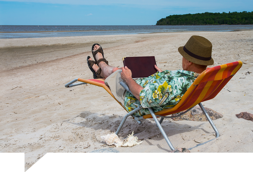 Man reading tablet on the beach