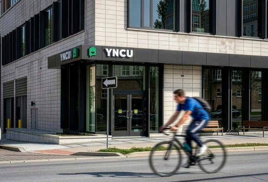 Man on a bike riding past YNCU Uptown Waterloo YNCU Branch
