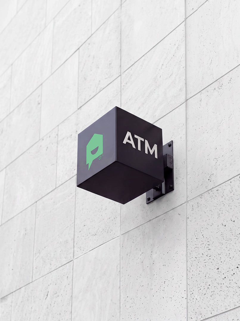 Black YNCU ATM sign on a white stone wall
